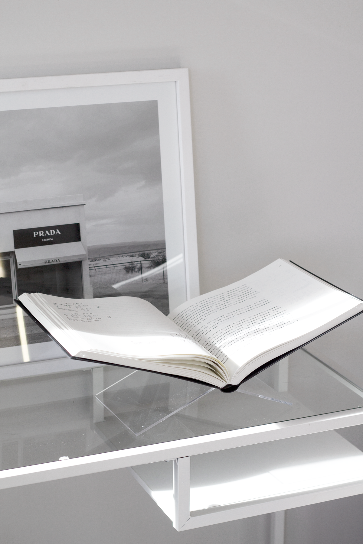 Clear acrylic book holder styled with candles and a vase