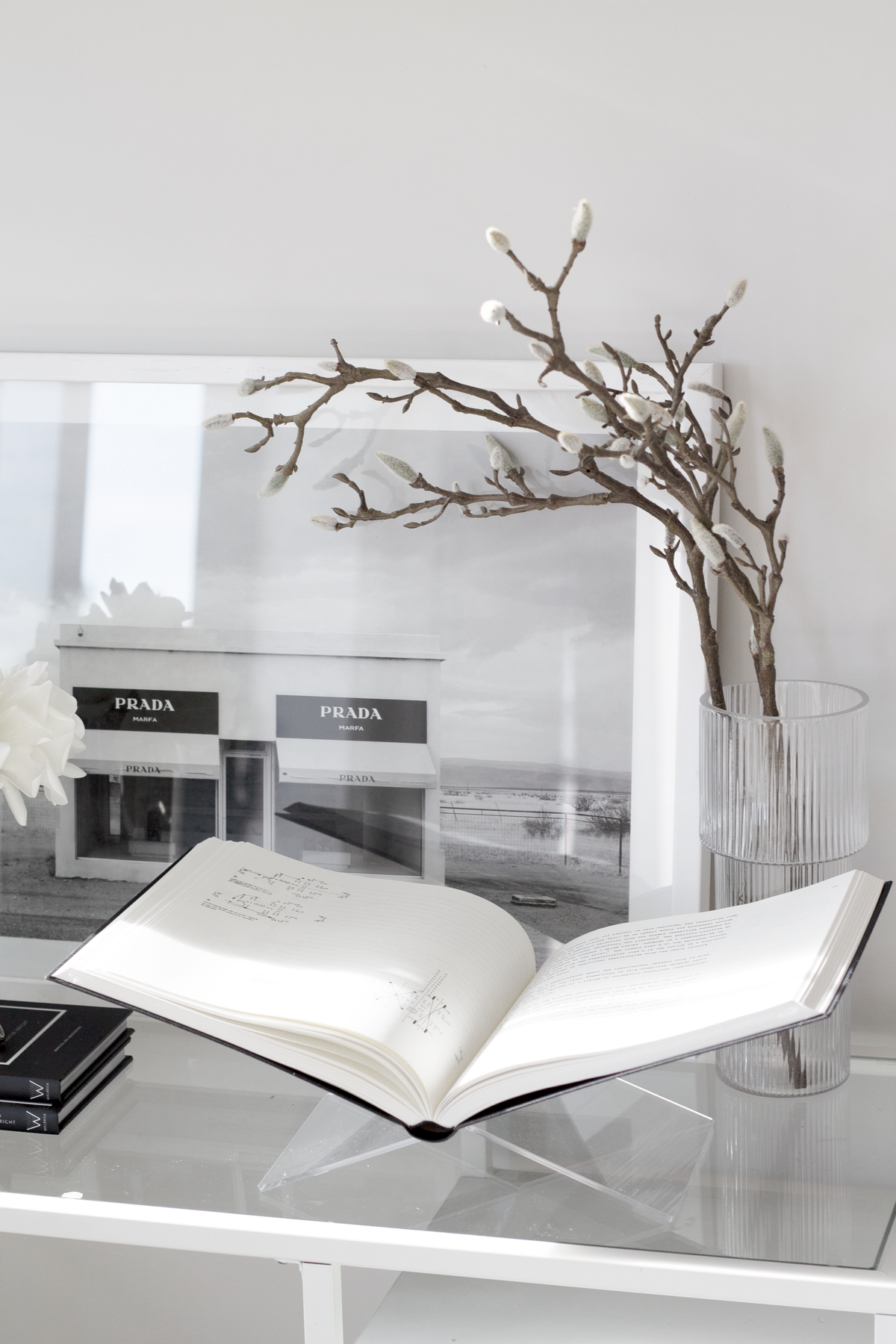Clear acrylic book holder displaying an open coffee table book