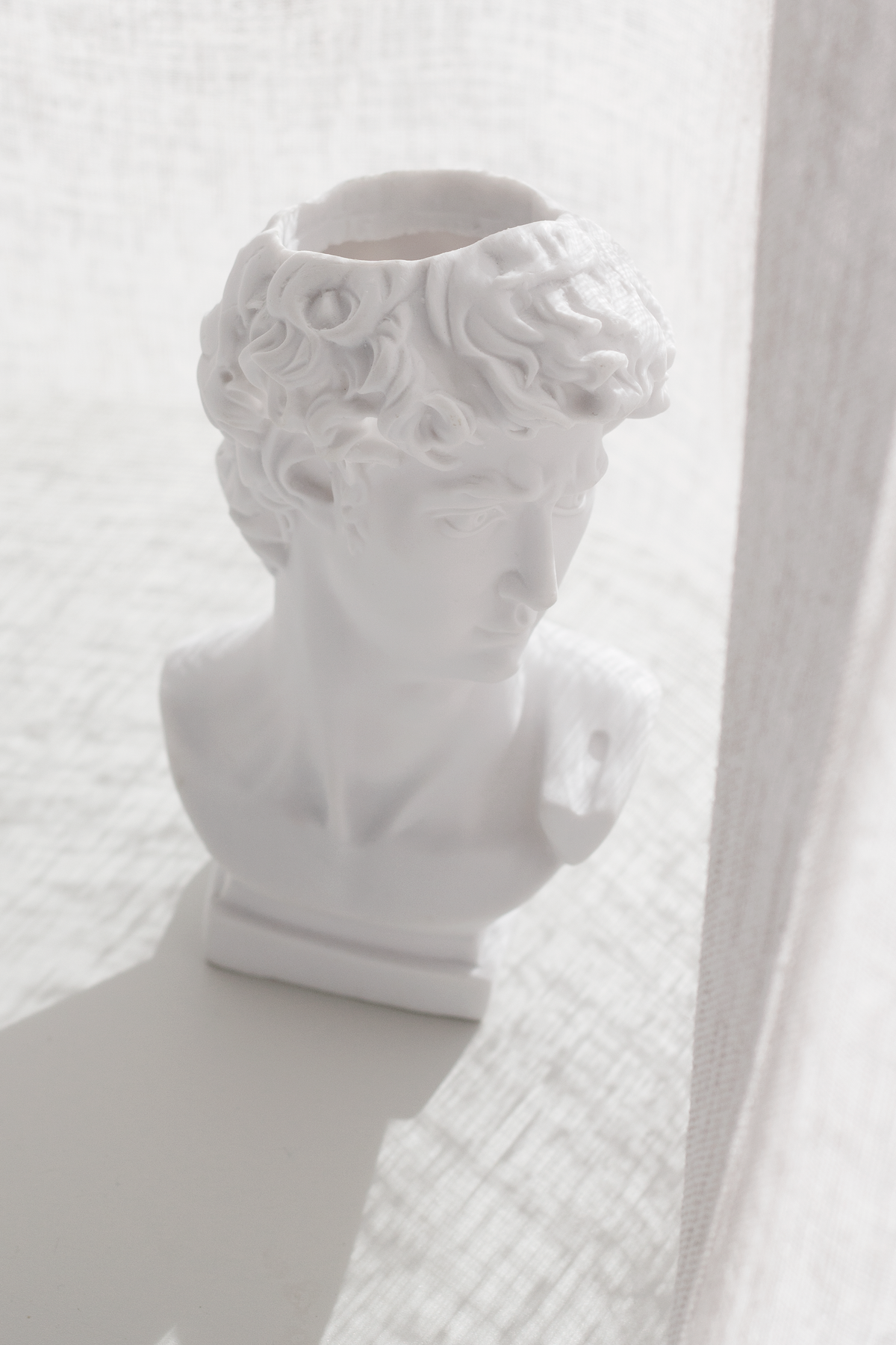 David vase beside a linen curtain, the open top clearly visible from above