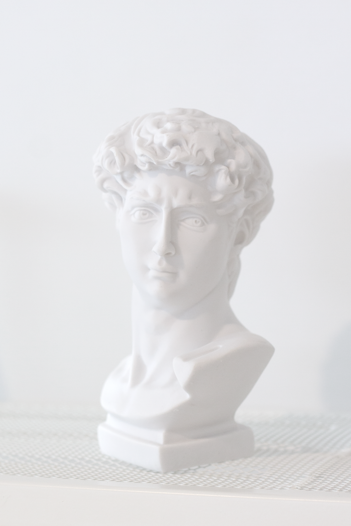 David vase seen from the front on a woven mat, curls carved across the brow