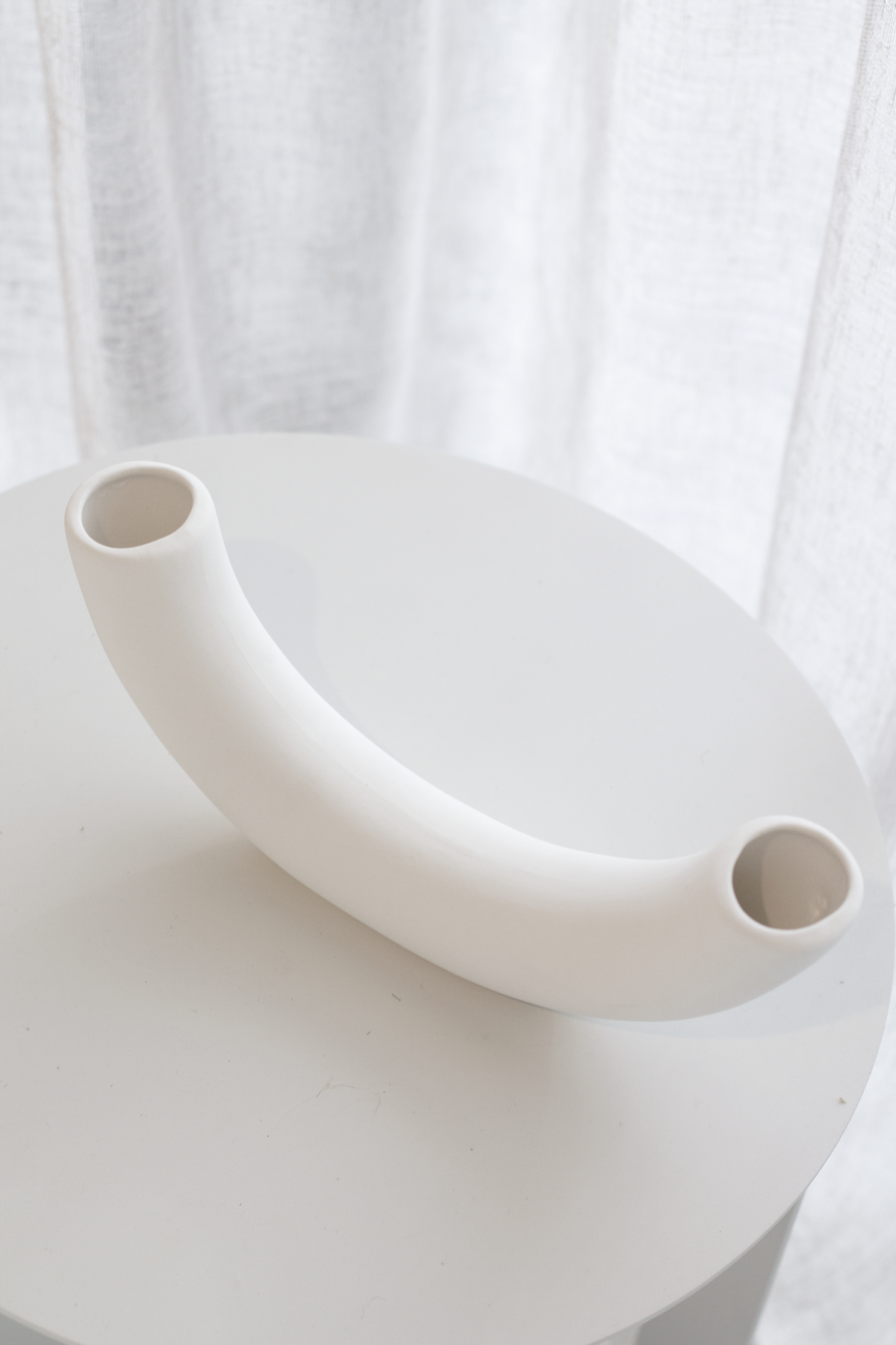 Looking down on the half pipe vase from above, both openings and the curve in view