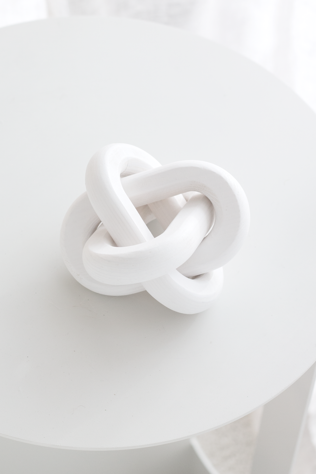 Looking down on the white knot ornament on a round white table