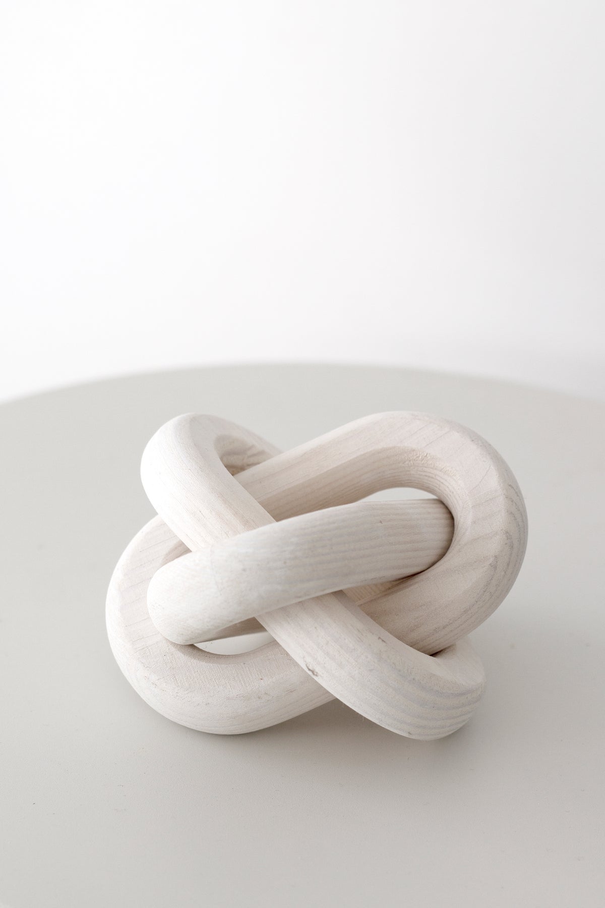 Natural wood knot ornament on a pale round table in soft daylight