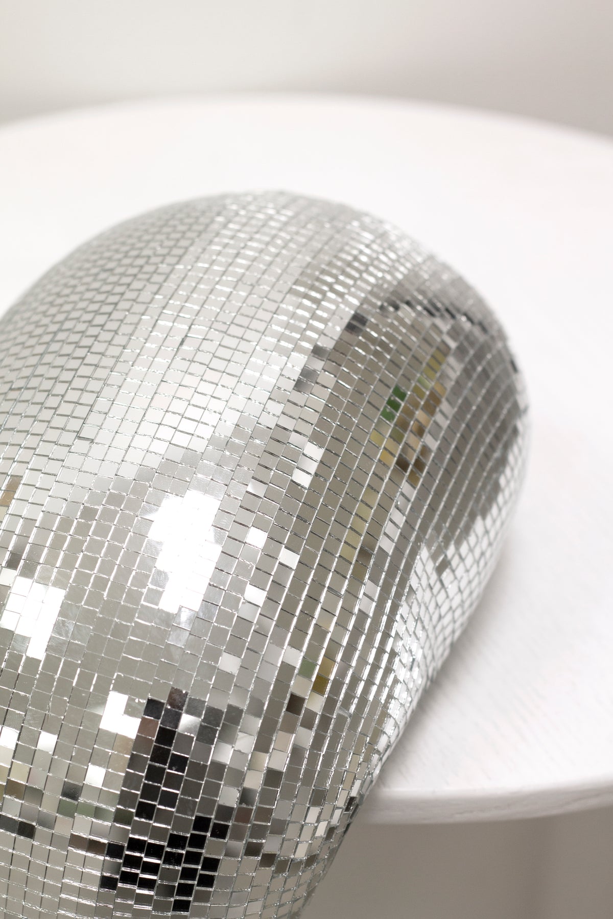 Melting disco ball draped over the edge of a round white table