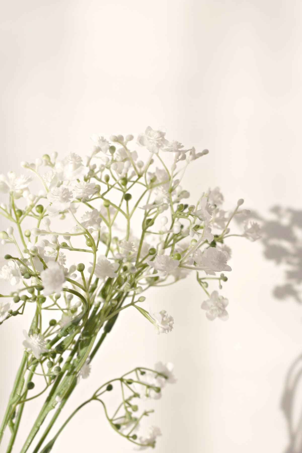 Faux gypsophila stems resting on a pale surface