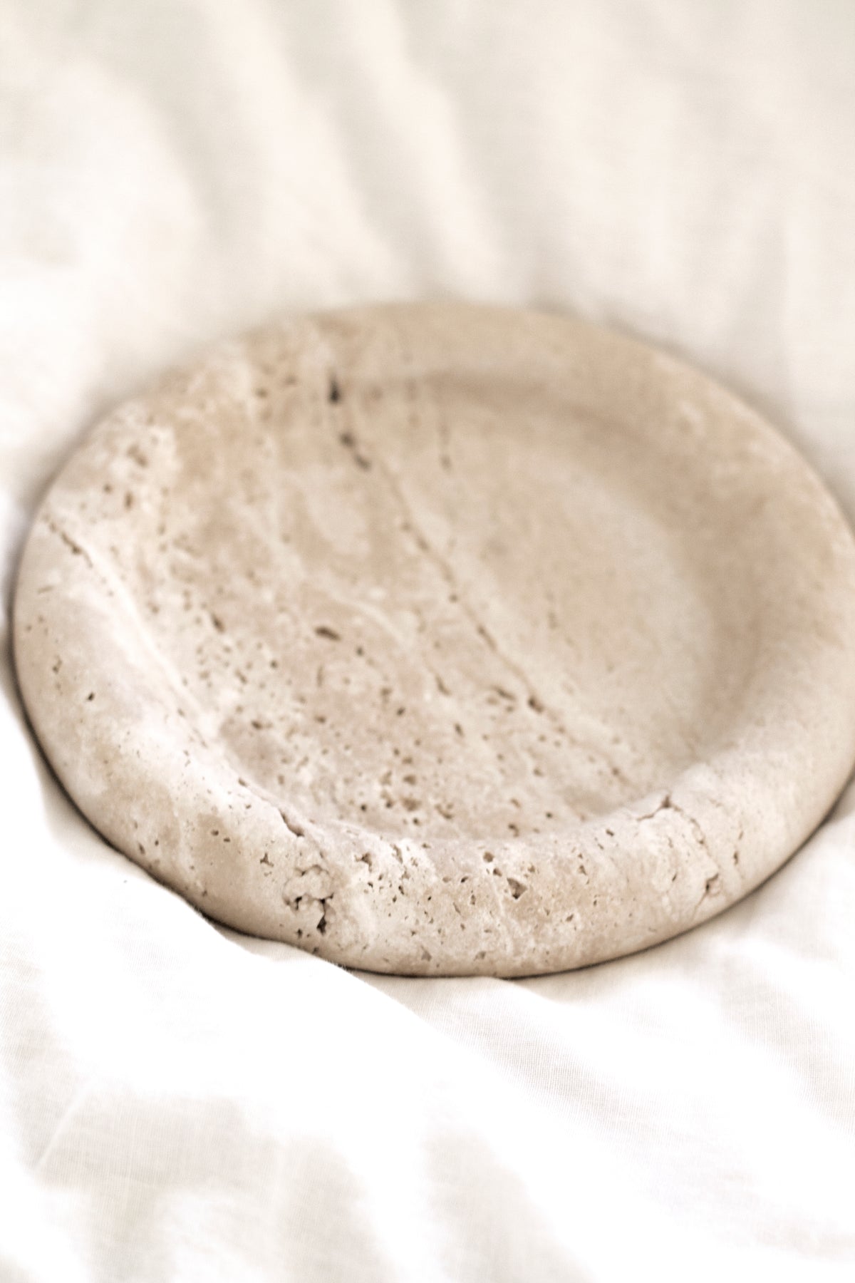 Bay Round Tray resting on white linen bedding