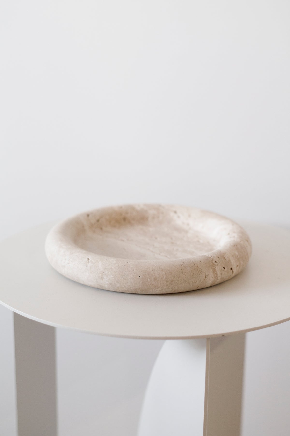 Bay Round Tray on a white side table, side view showing its rounded rim