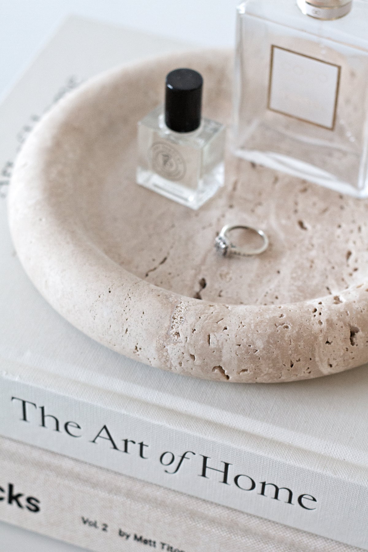 Bay Round Tray holding two perfume bottles and a ring on a stack of coffee table books