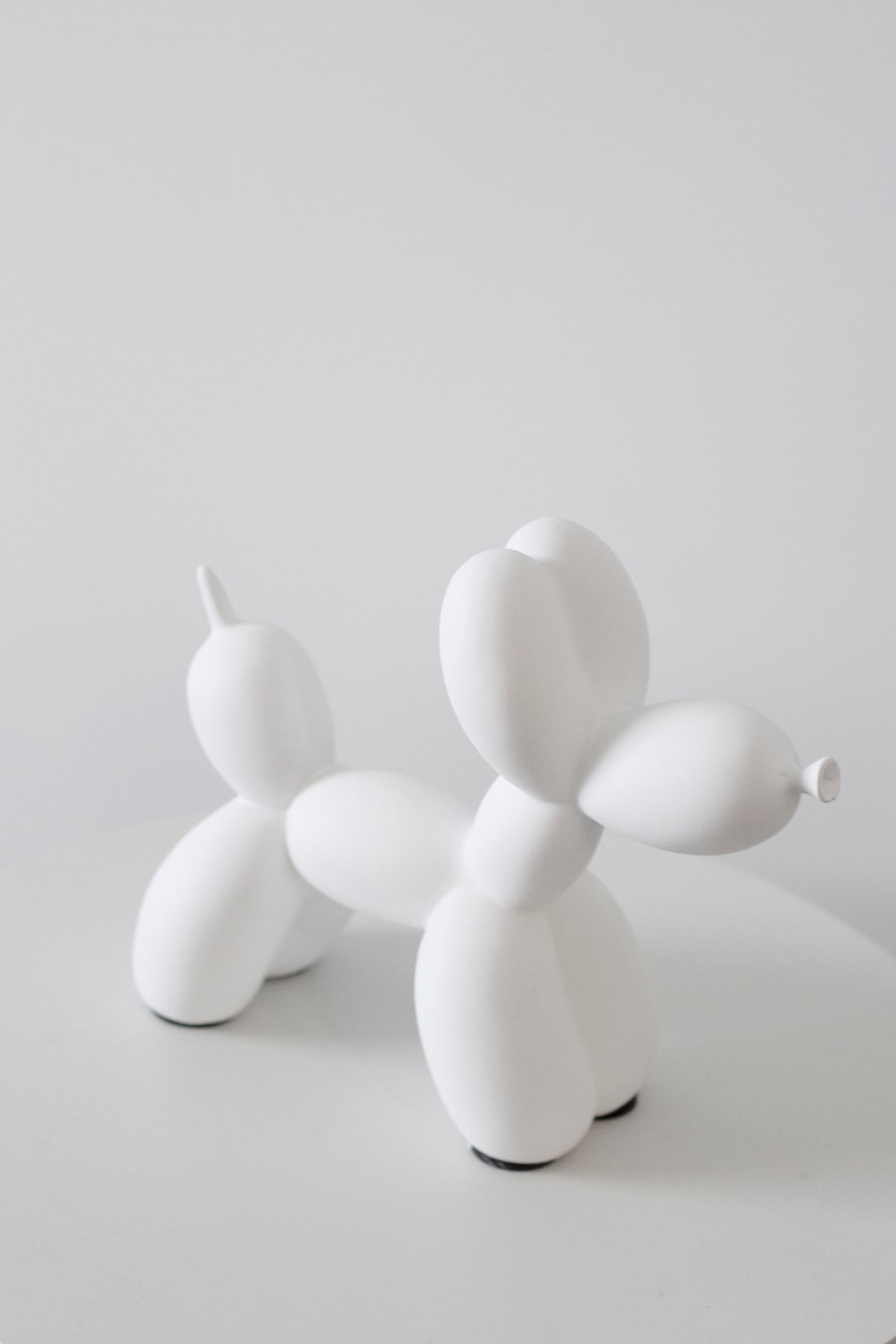 White ceramic balloon dog sculpture on a pale grey background