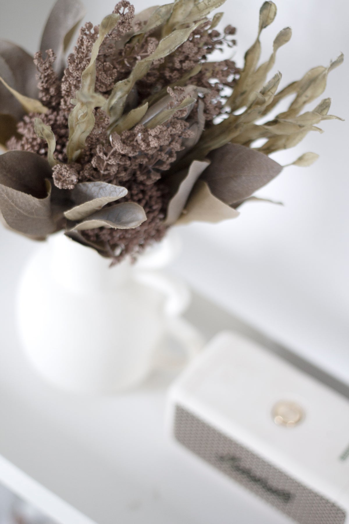 Chloe vase of dried florals on a white shelf, close and slightly above