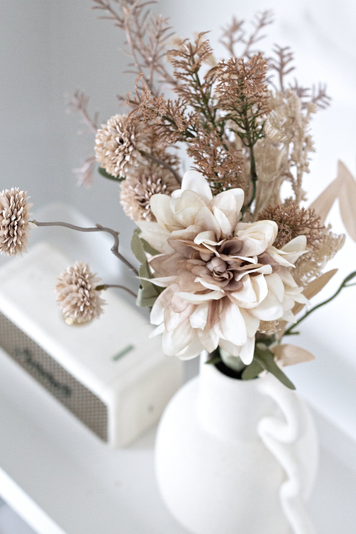 Chloe vase of blush dried florals on a white shelf beside a small speaker