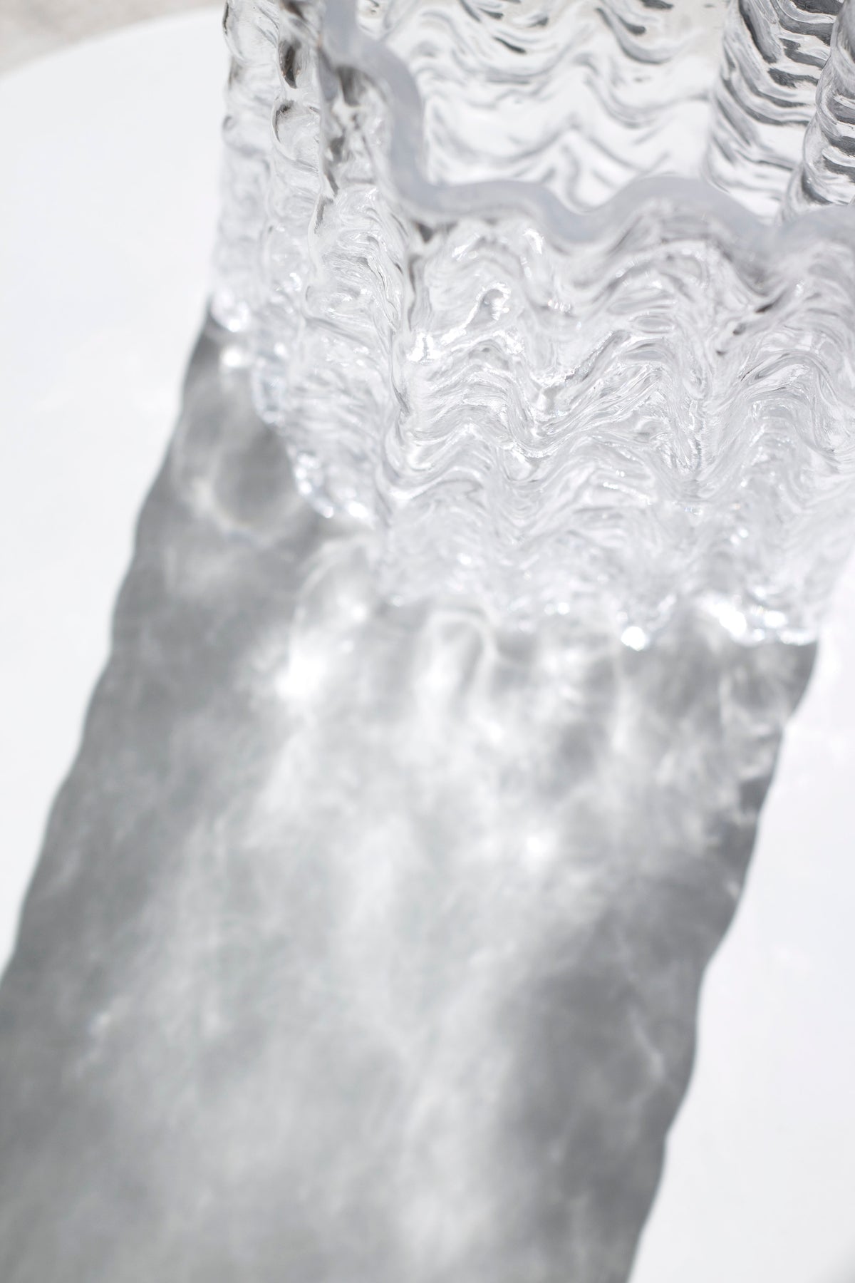 Close up of the clear Glacier vase rim with water sitting inside