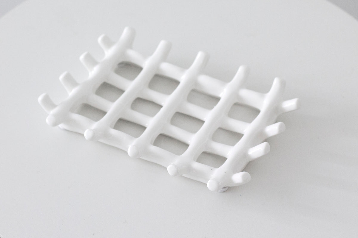 Angled close view of the soap dish lattice, the woven bars crossing over one another
