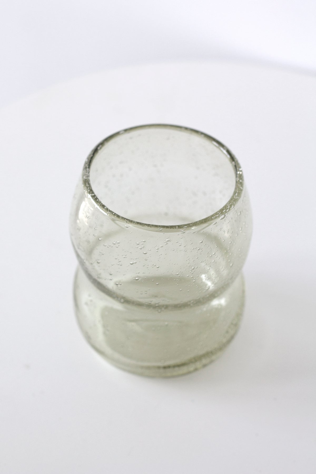 Light amber tumbler on a white table, seen from slightly above