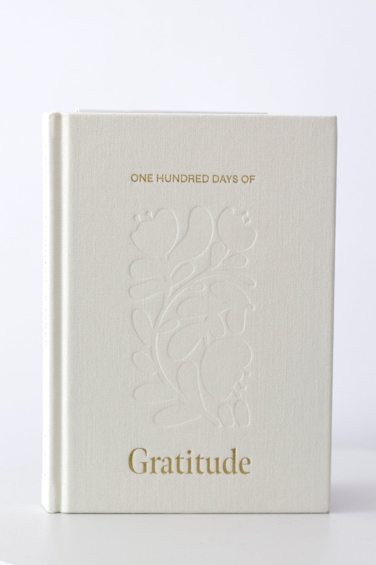 Straight-on view of the debossed floral linen cover and gold Gratitude title