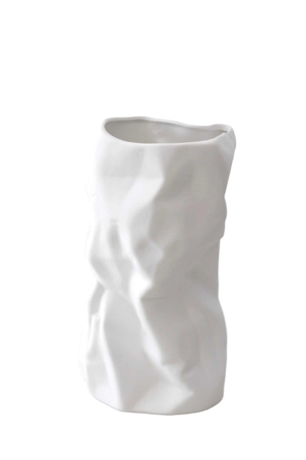 Crumpled ceramic vase in white, folded sculptural form on a plain background