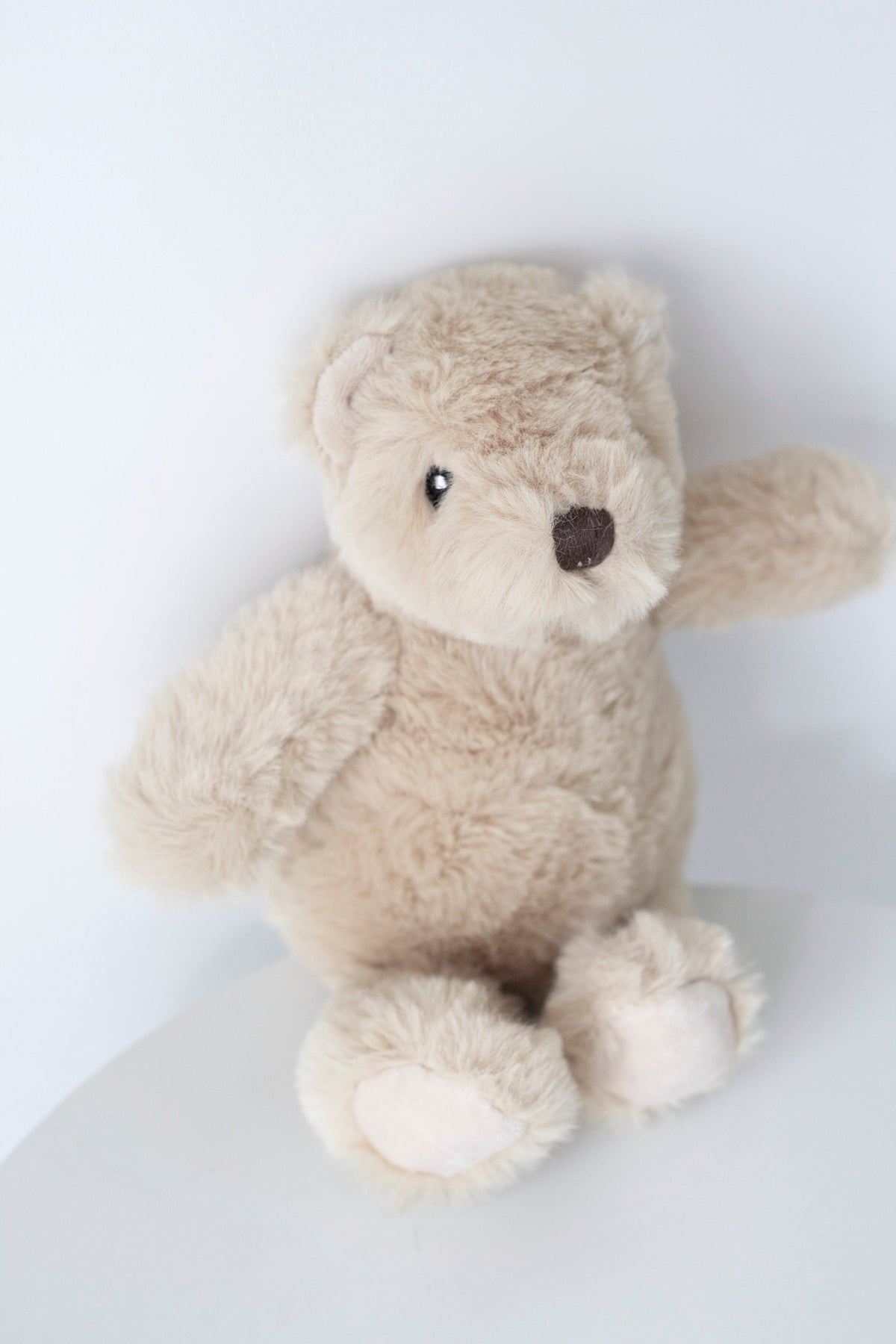Fawn Littlefoot Bear soft toy seated, showing its stitched face and paw pads