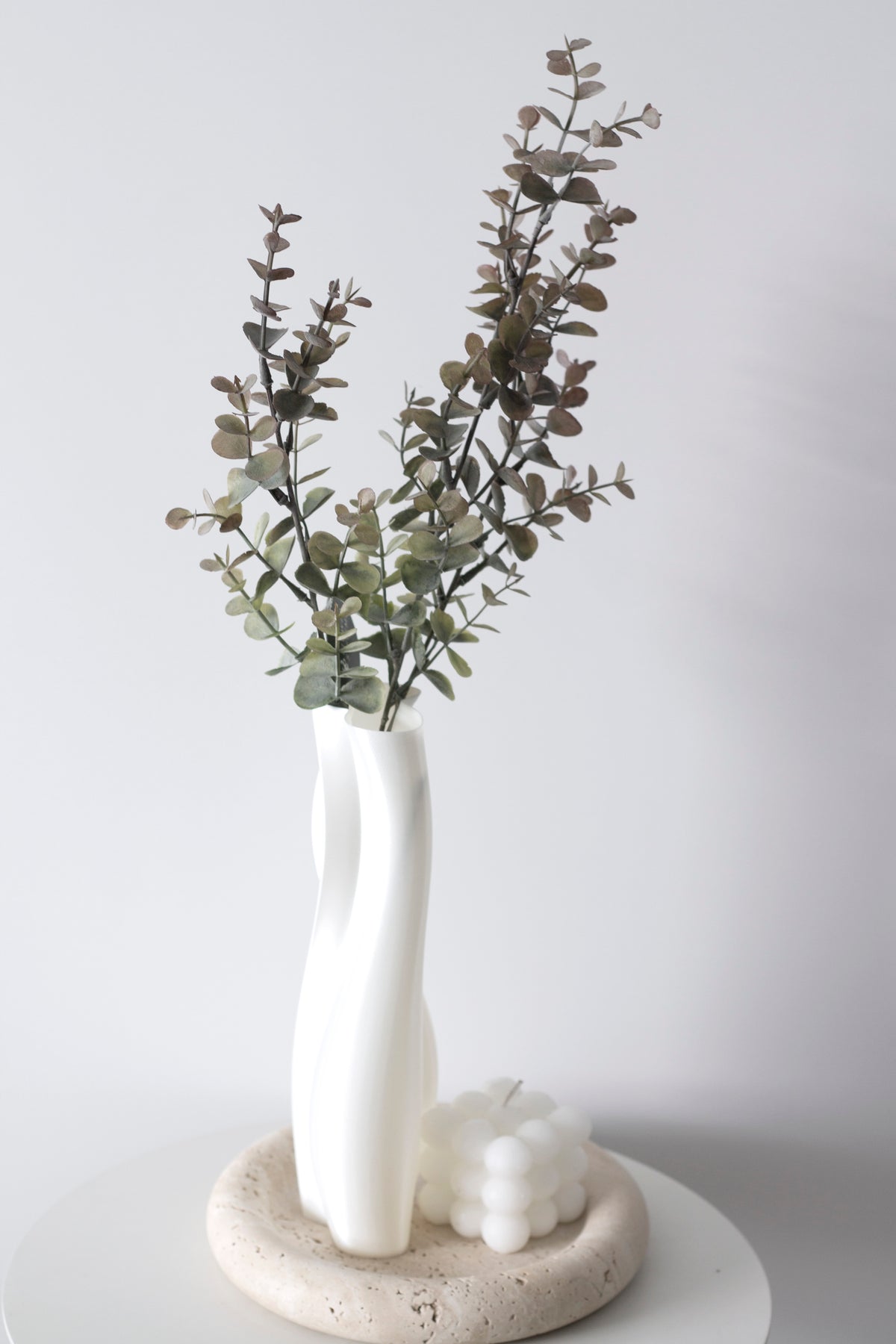 Faux silver dollar eucalyptus in a slim white vase
