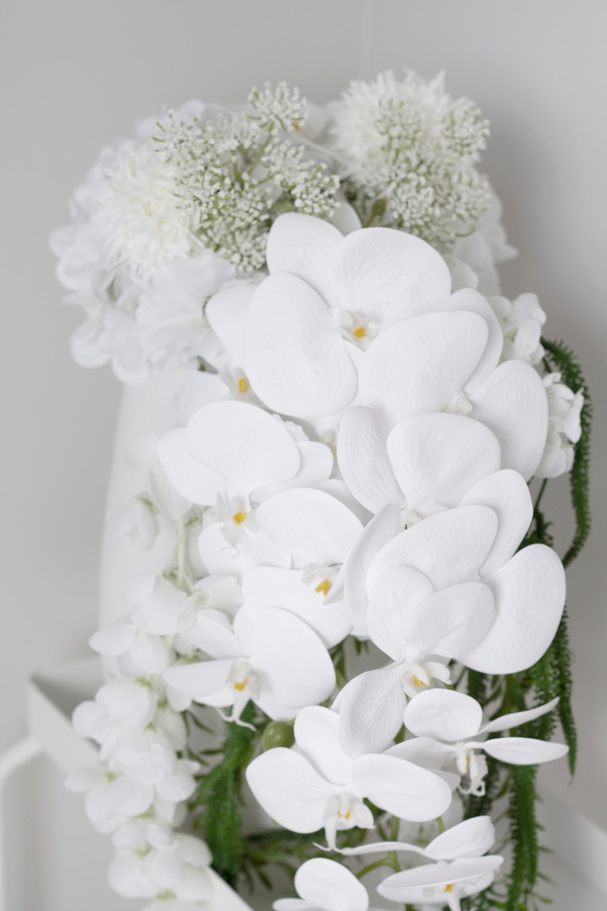 Detail of the large white orchid petals set against clustered hydrangea florets