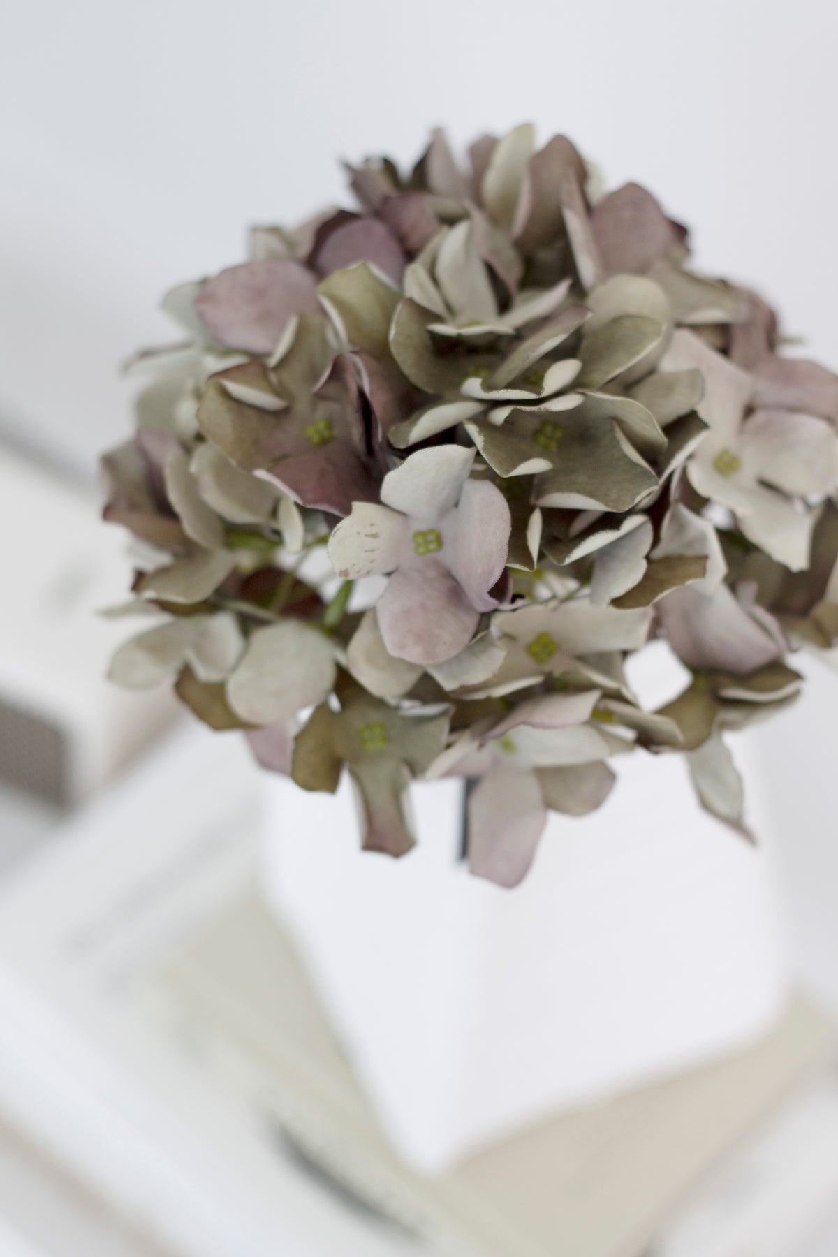 Close-up of the green faux hydrangea's layered petals with mauve tones