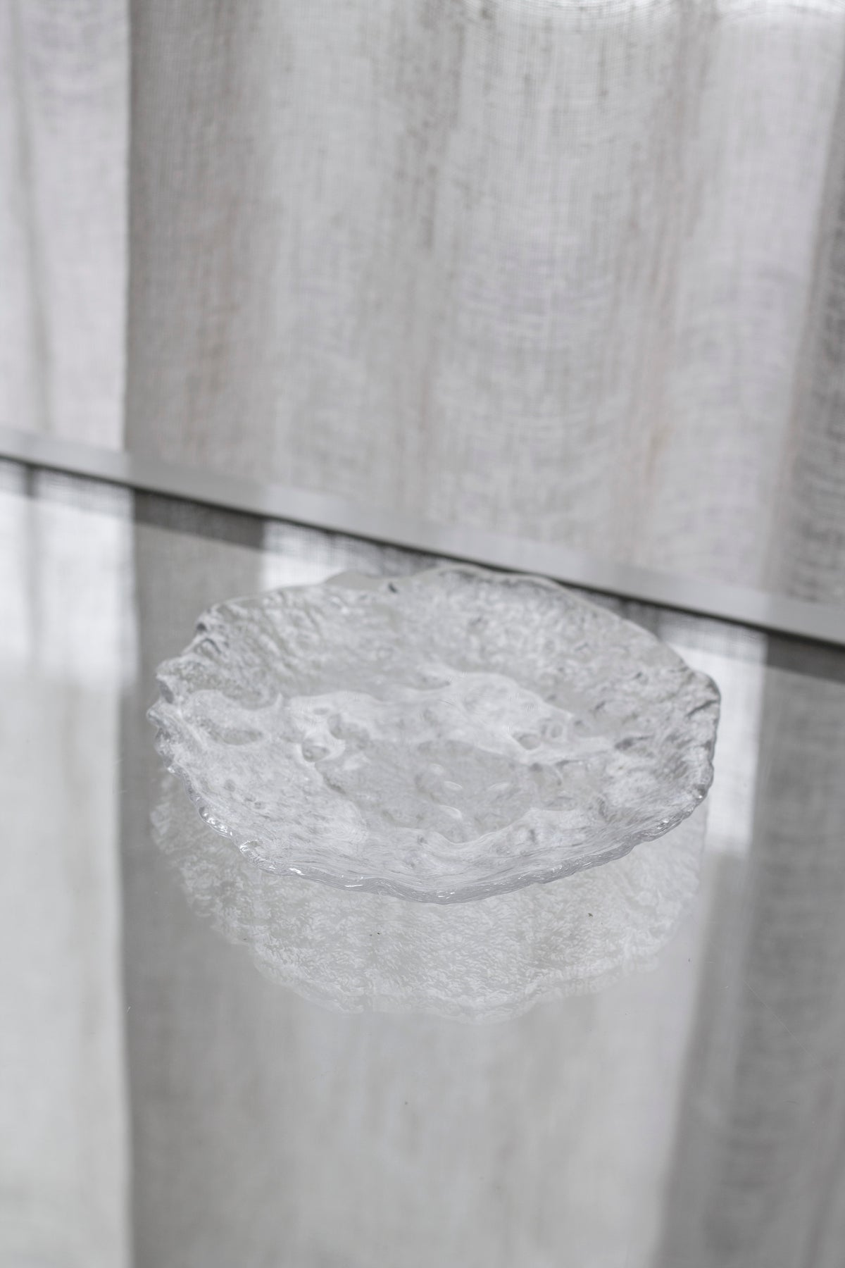 Glacier glass tray on a pale ledge with a linen curtain behind