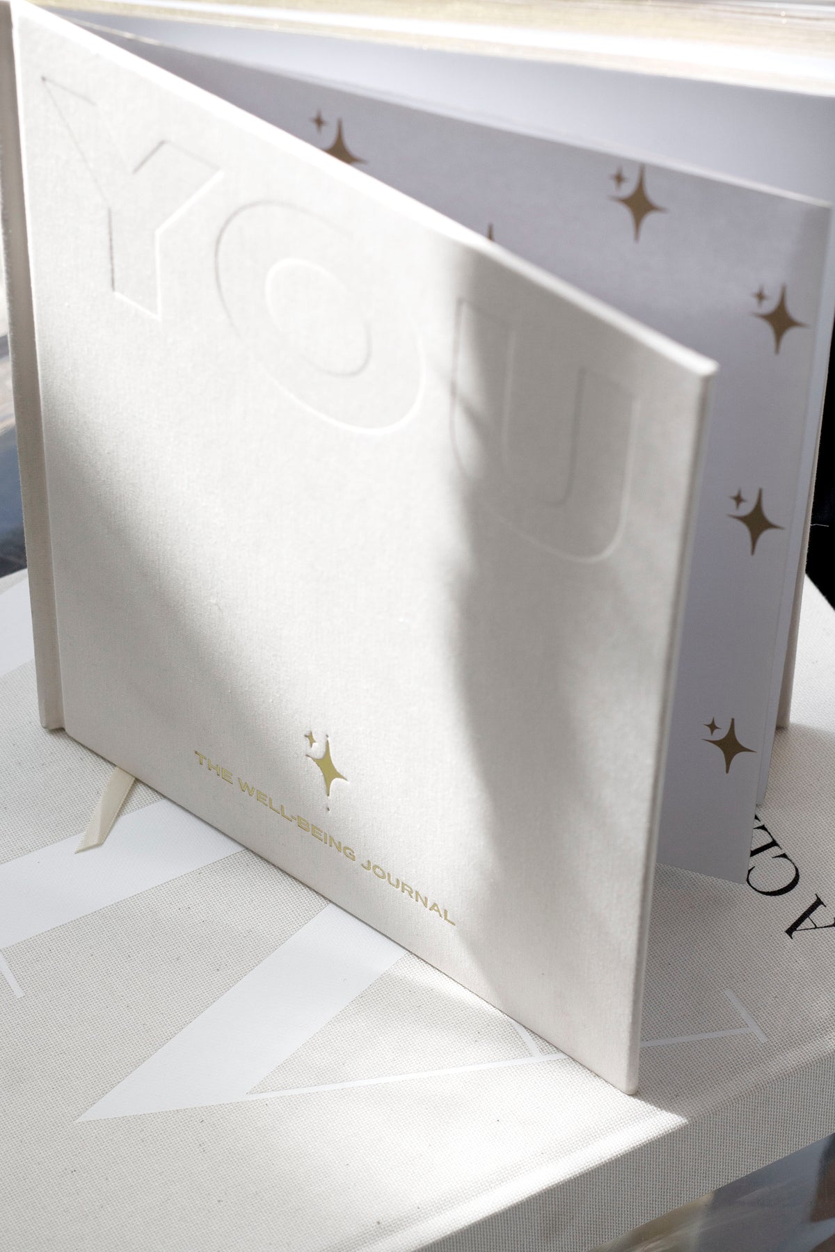 The YOU. journal shown with its printed gift box, both marked with the small gold star motif