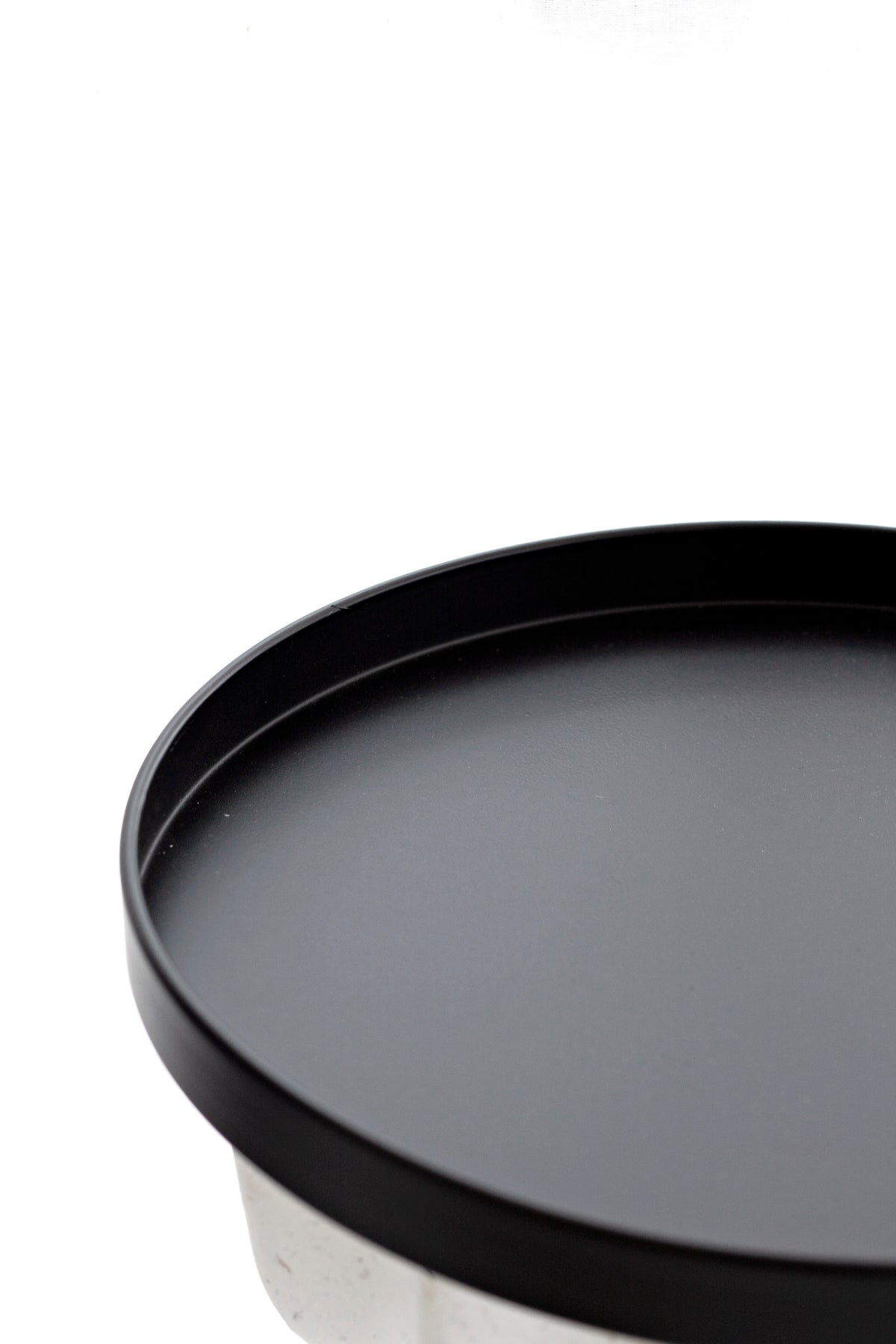 Close up of the black Bianca tray rim and flat base on a pale round tabletop