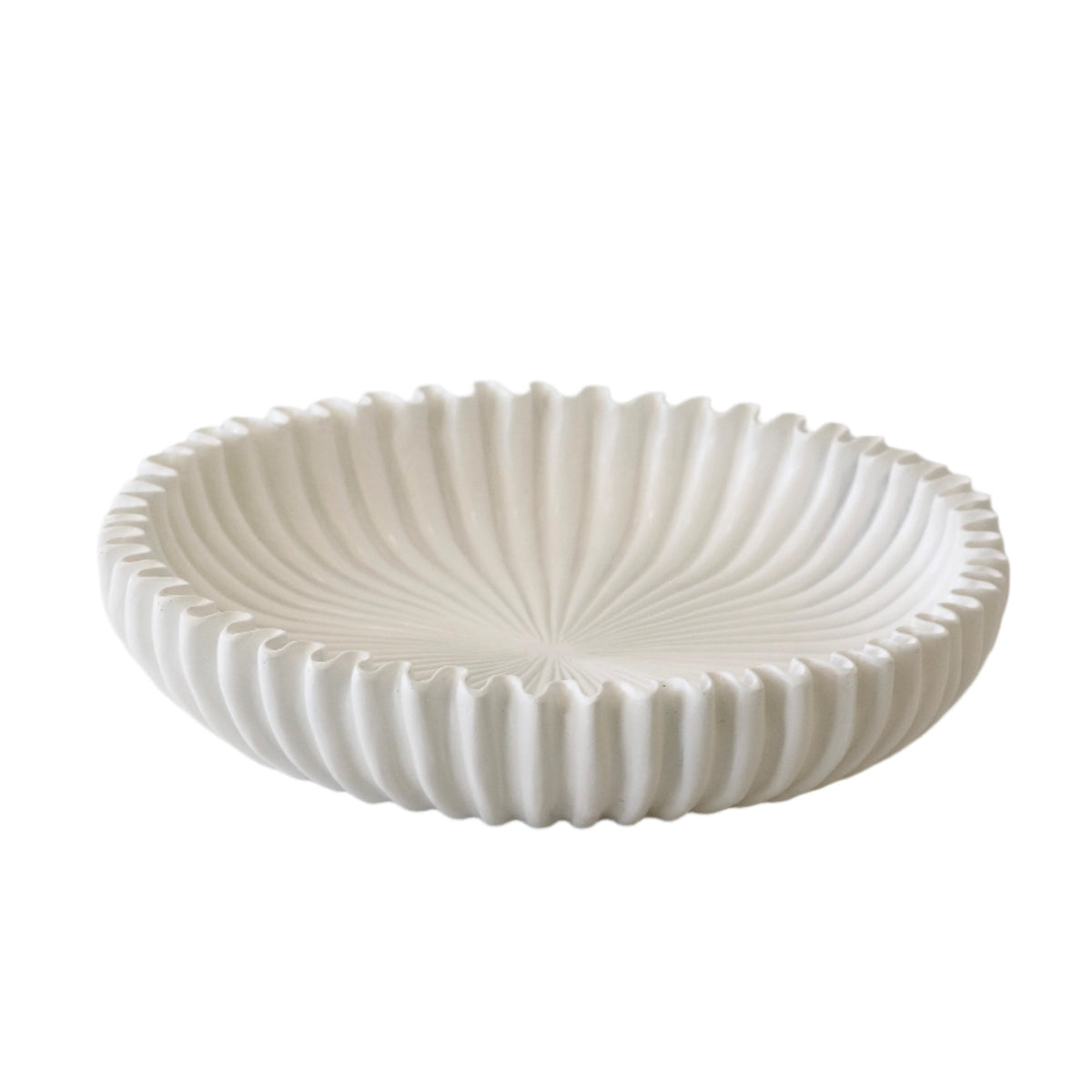 Nude scalloped resin platter styled as a catchall on a console
