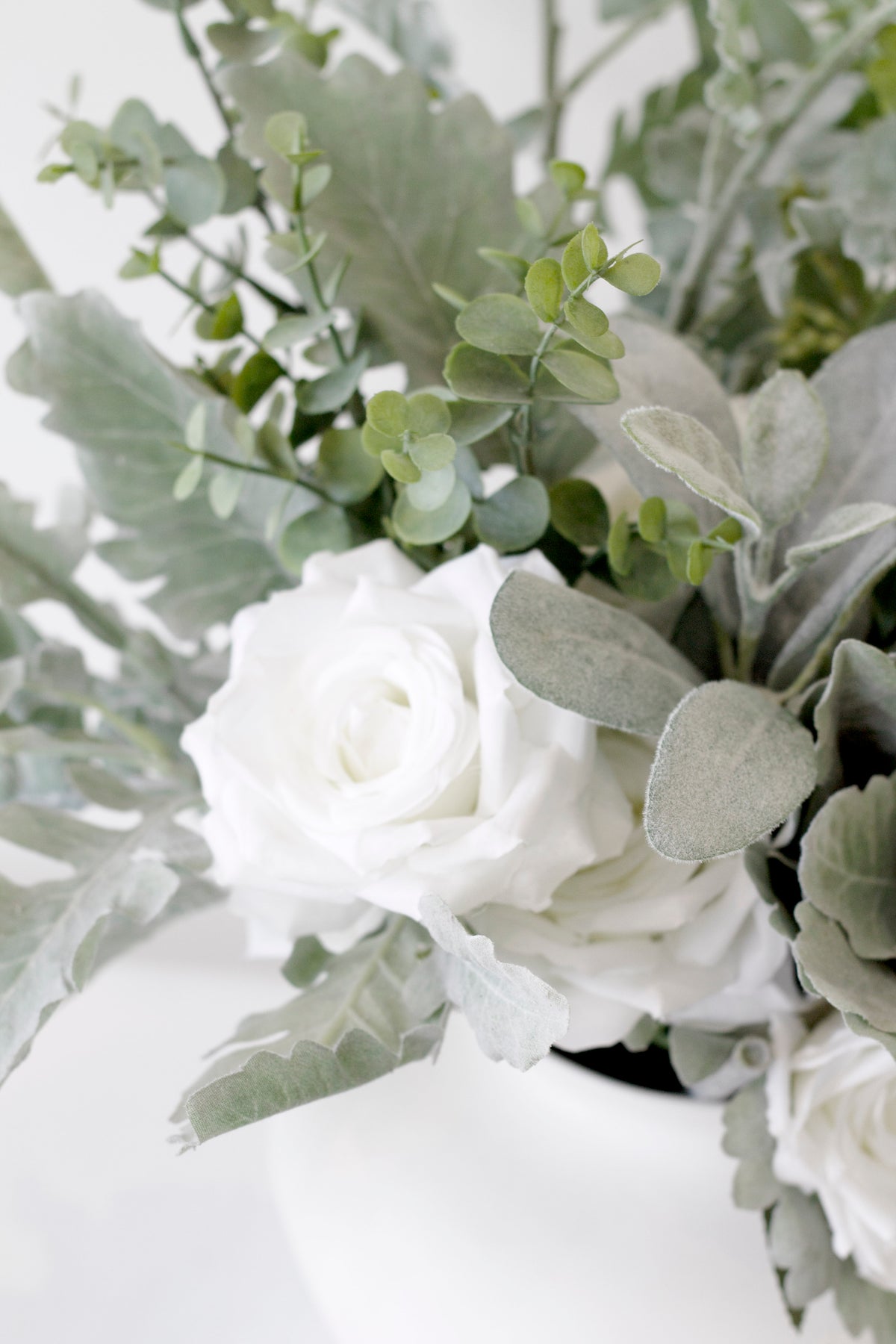 Lamb's ear with white roses in a white vase, close view