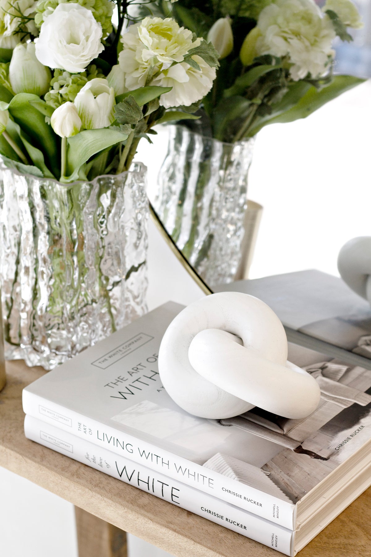 The Art of Living With White book styled with candle and vase