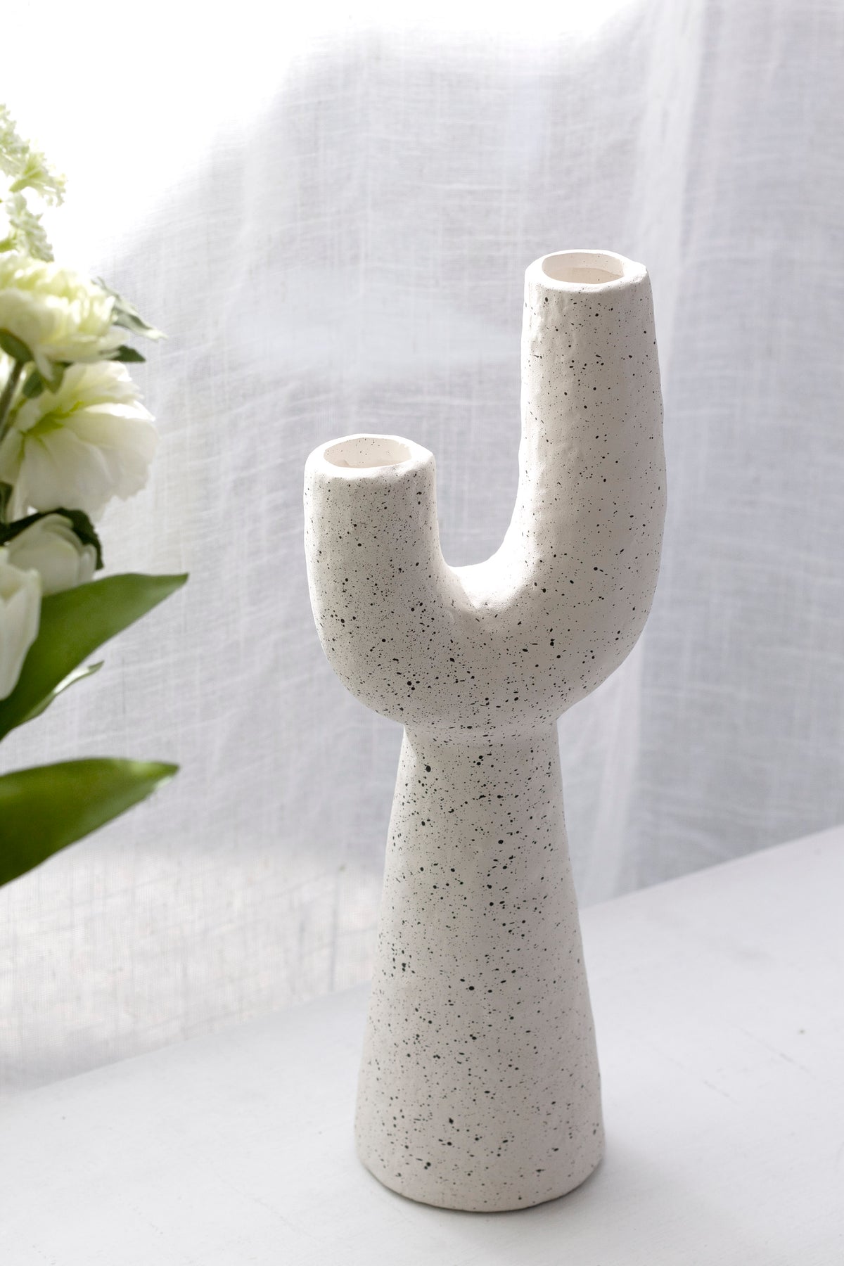 Close view of the Franki vase's speckled texture beside white flowers