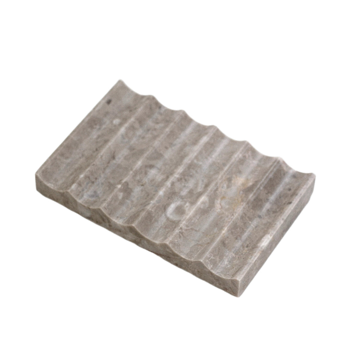 Rectangular travertine tray carved with a fluted wave surface, mottled grey-beige stone on white