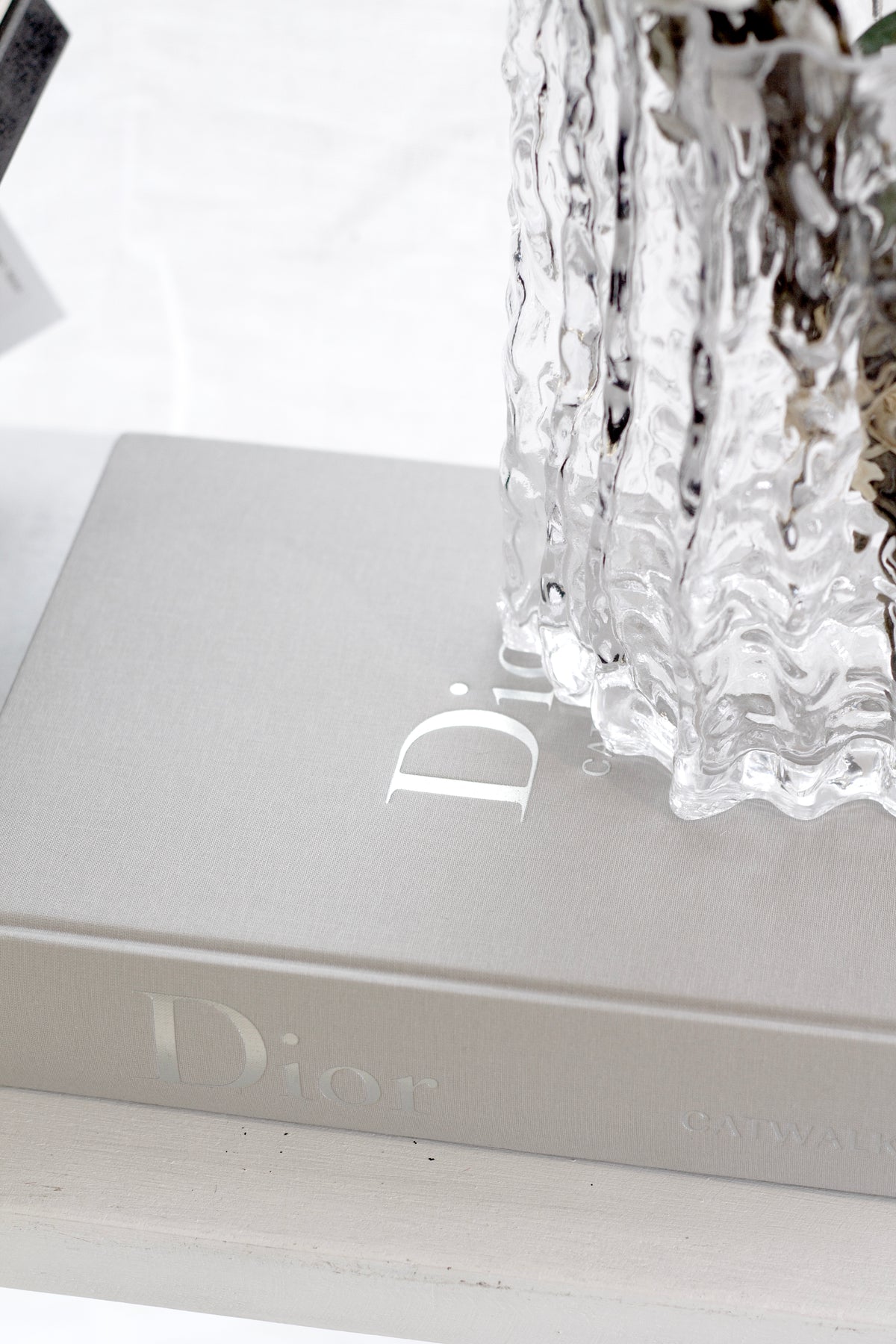 Dior Catwalk book styled with a candle and vase