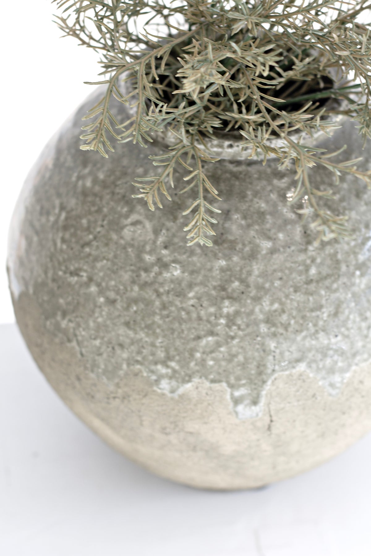 Rosemary sitting low in the round crackle glazed vase, its texture in close view