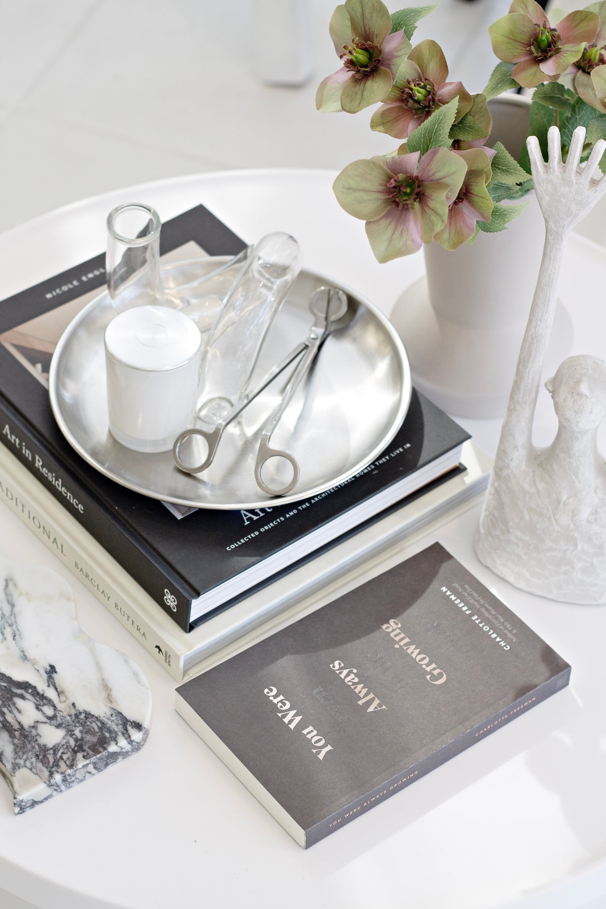 Clear J-Curve vase on a round tray with a candle and scissors beside stacked books