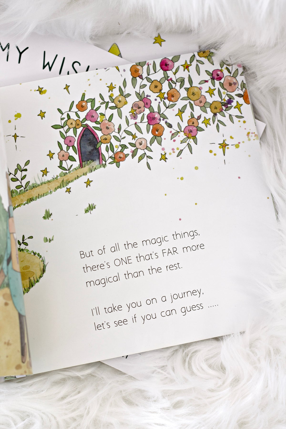 Open page of In a World Full of Magic with a flowering tree illustration, on a white sheepskin