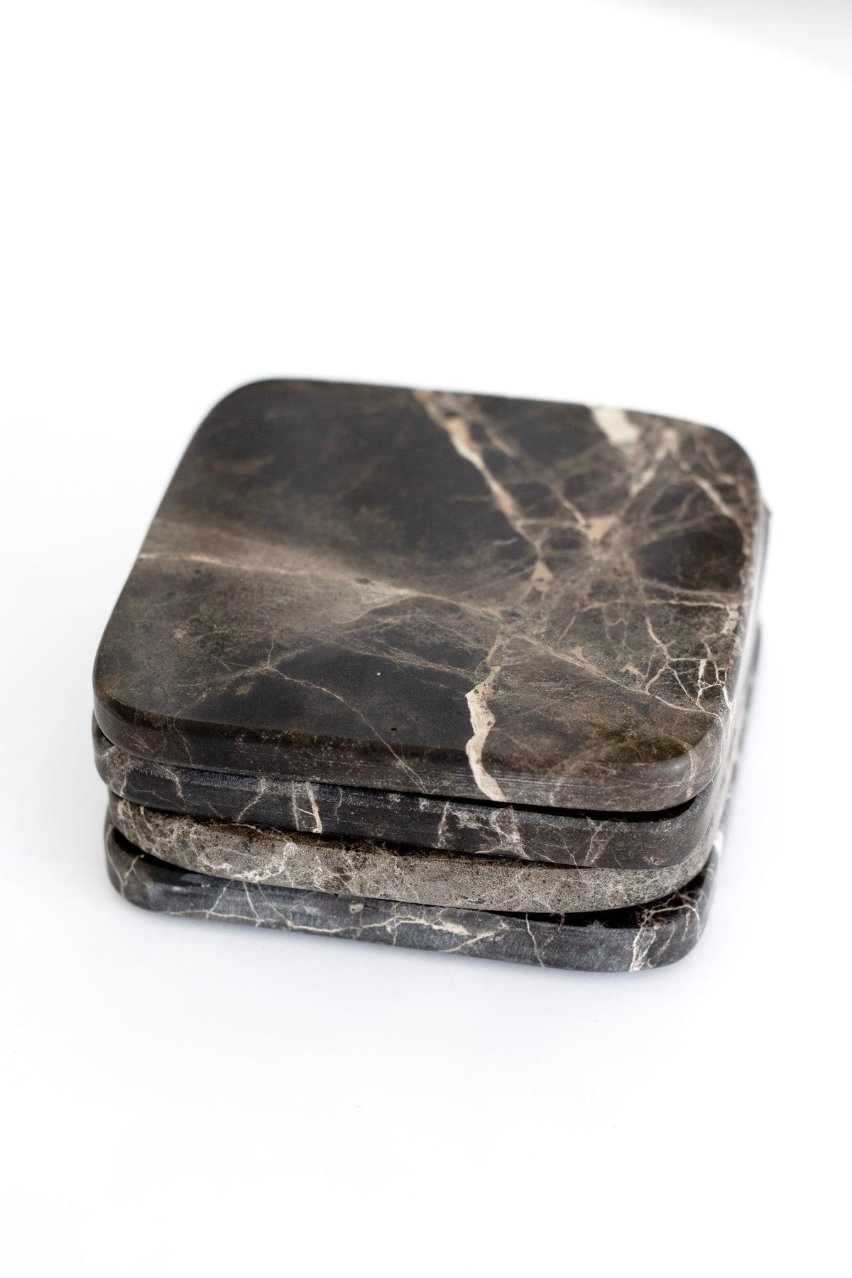 Stack of dark marble coasters with fine gold veining