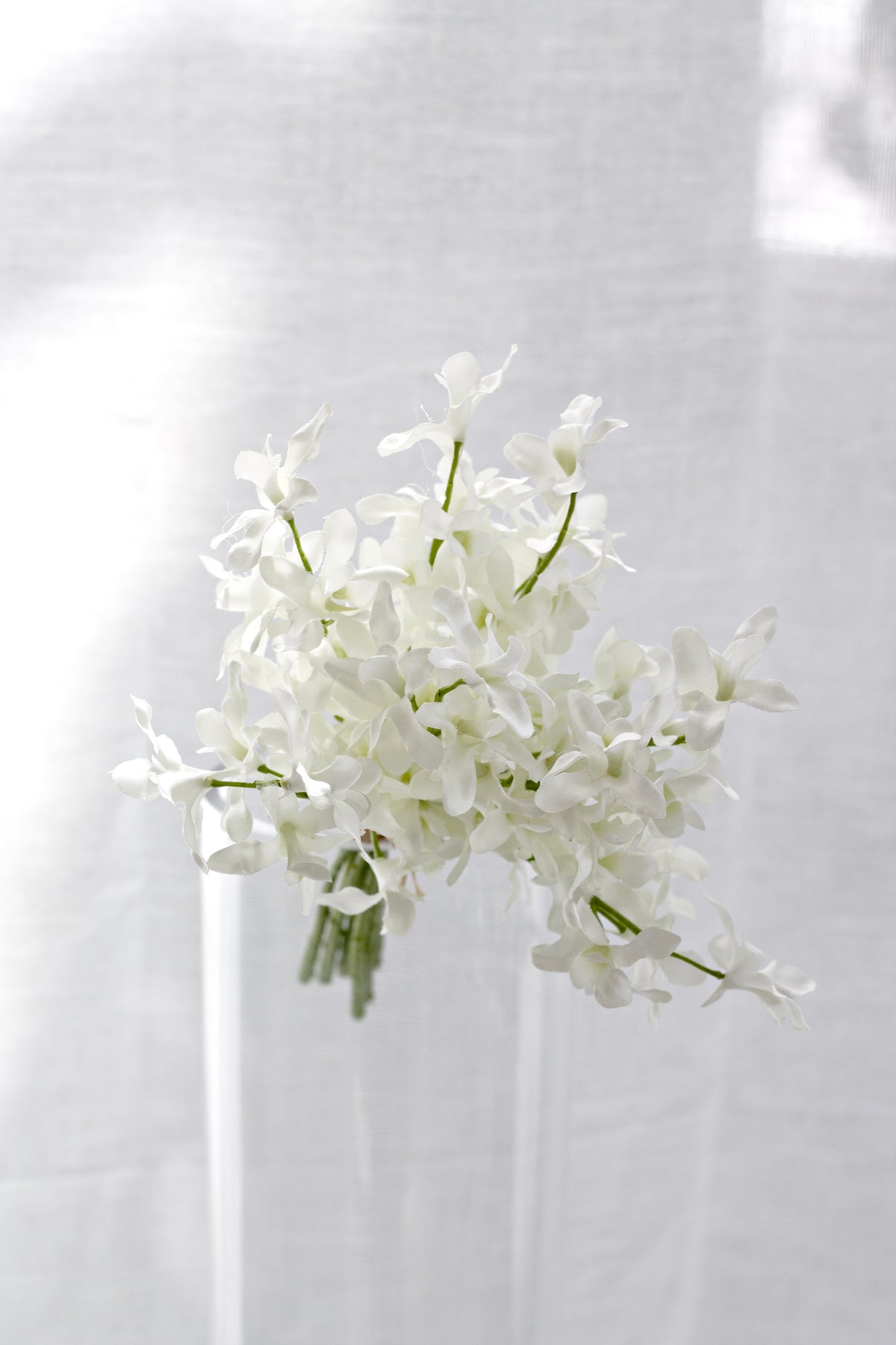 Faux orchid bundle standing in a clear glass vase