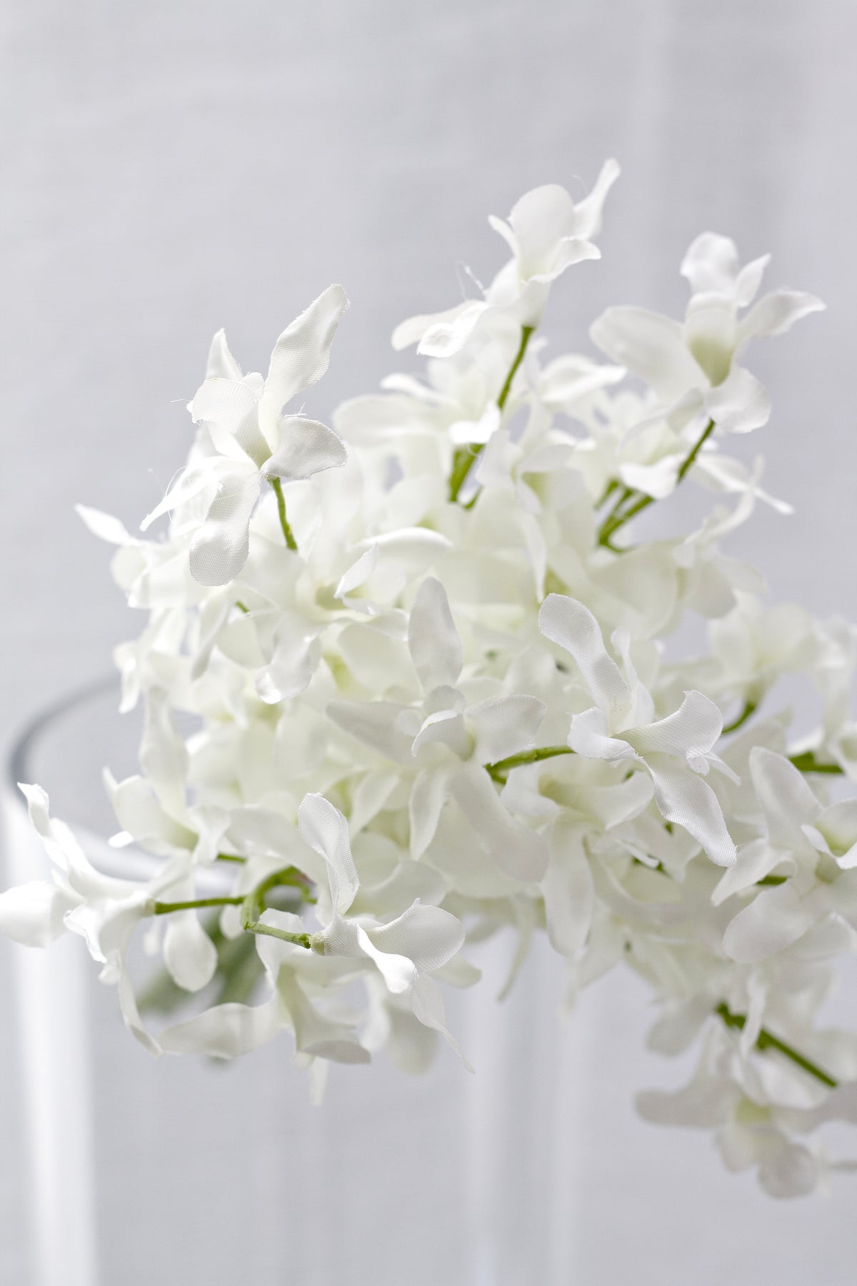 Close view of the faux orchid blooms in a glass vase