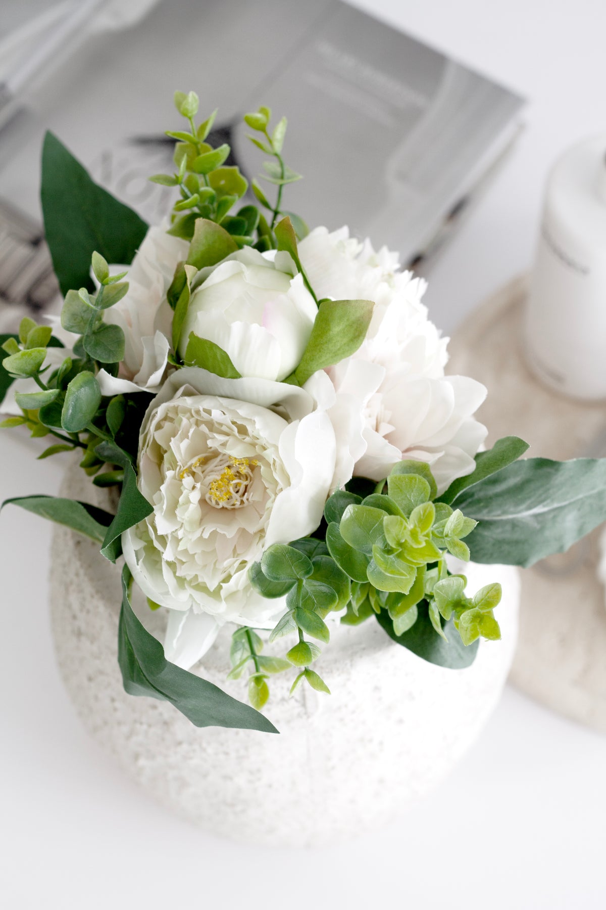 Blush dahlia and cream peony faux bouquet in a white speckled vase beside a white tray