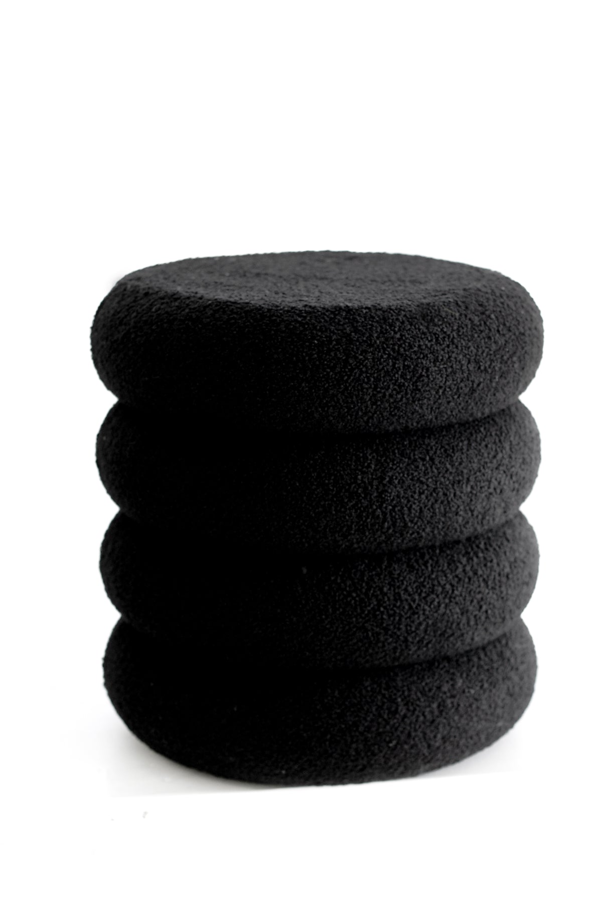 Black tiered boucle ottoman, four stacked rounds against a white background