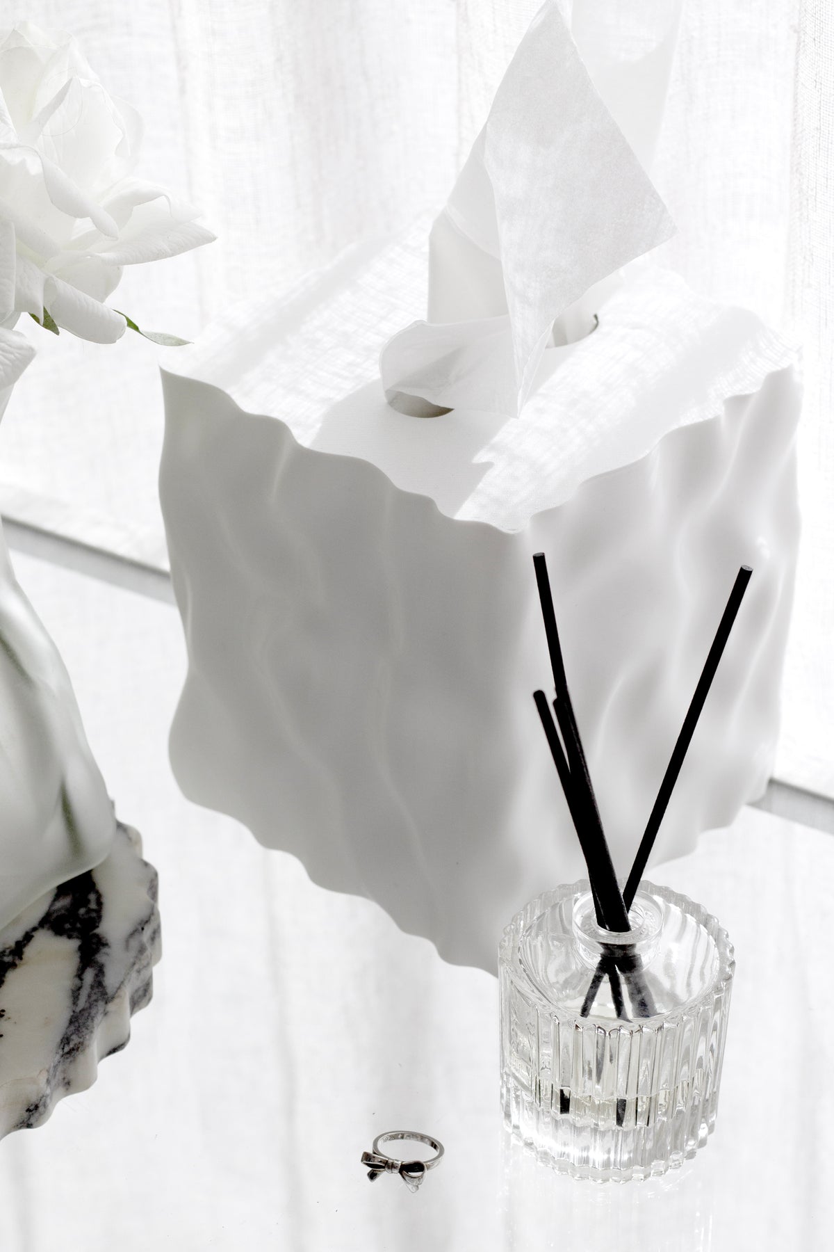 Ecoya Celebration diffuser on a white shelf beside a white wavy tissue box