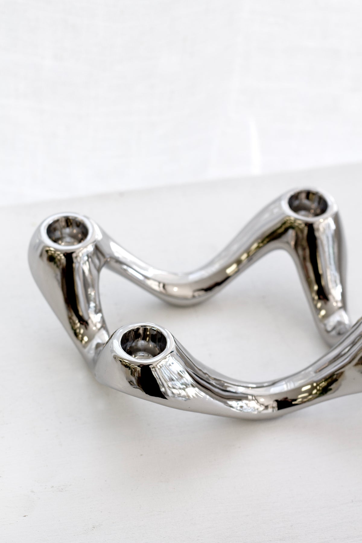 Close view of the silver candle holder on white, the four sockets clearly visible