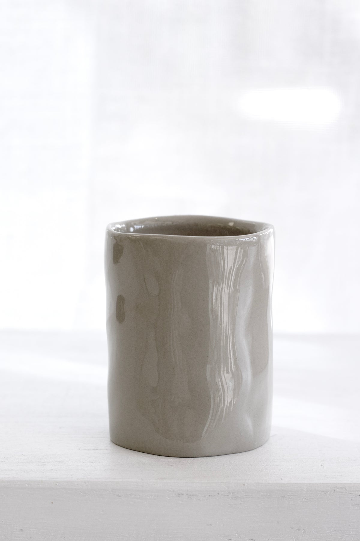Cashmere tumbler on a white ledge in soft window light