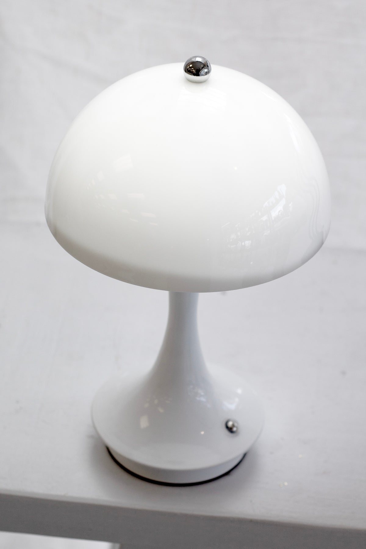 Close up of the white mushroom lamp unlit, showing the domed shade and slim stem