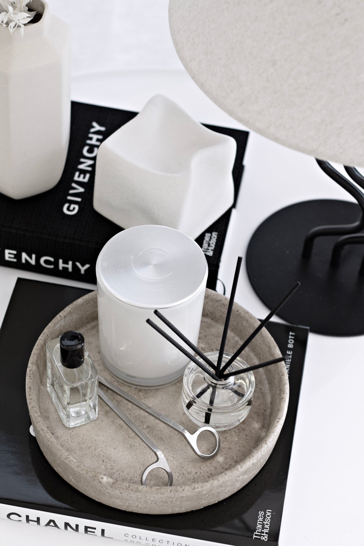 White Cubic Crush cube on books beside a stone tray holding a candle, diffuser and trimmer