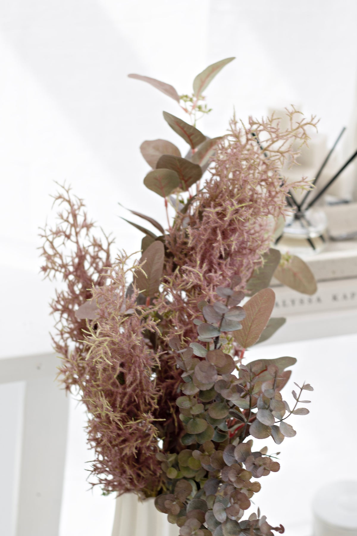 Faux eucalyptus with dried pink grasses in a soft arrangement