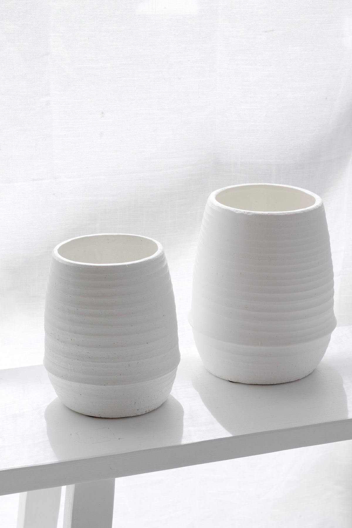 Small and medium Alma chalk vases side by side on a white shelf