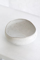 Speckled ceramic bowl on a white surface