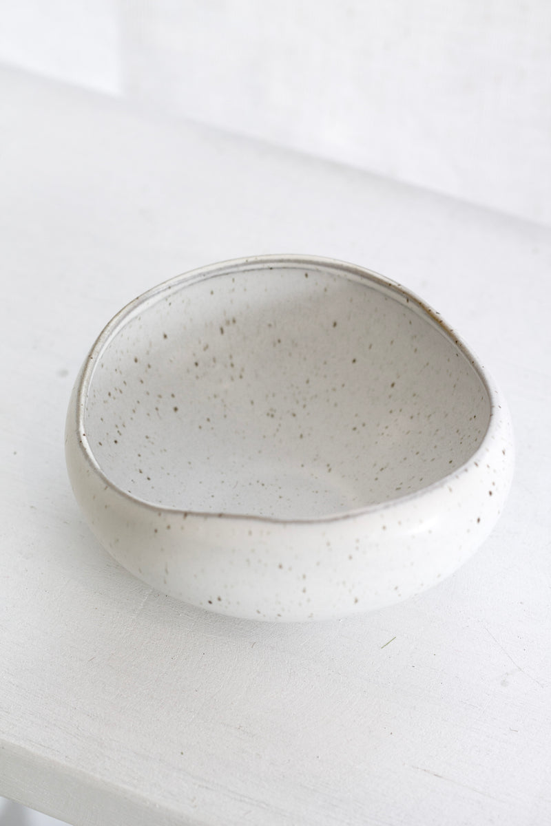 Speckled ceramic bowl on a white surface
